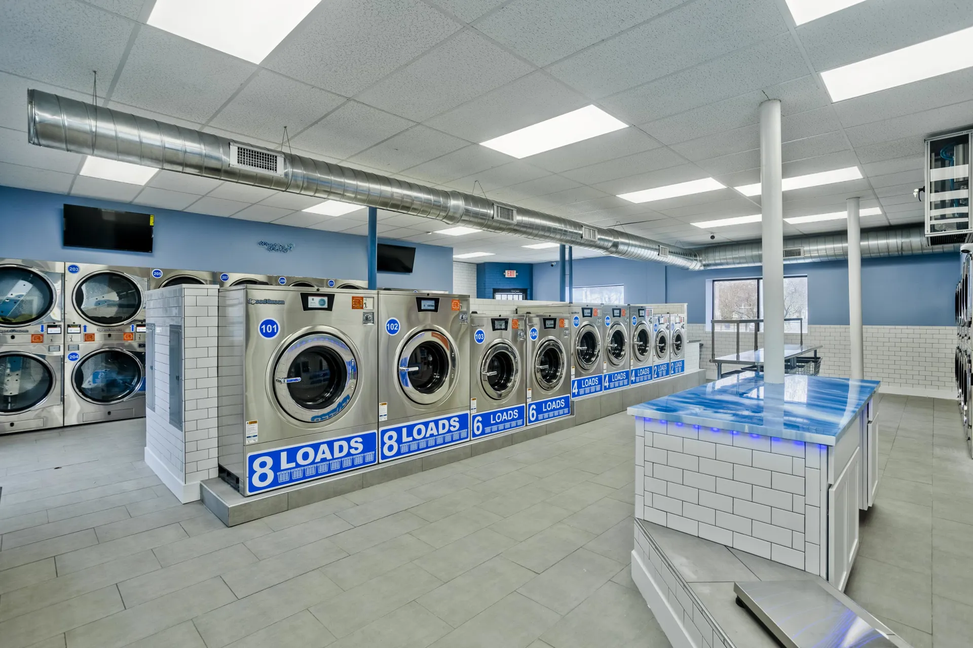 An attended full-service laundromat with customers handling laundry