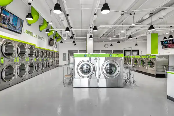 A modern laundromat fit-out with green accents and pendant lighting
